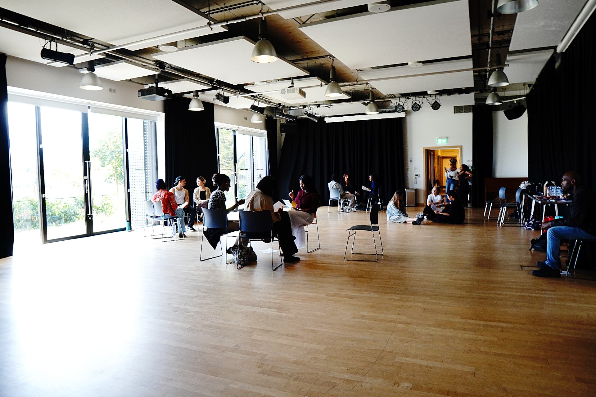 Small groups rehearsing across the workshop studio